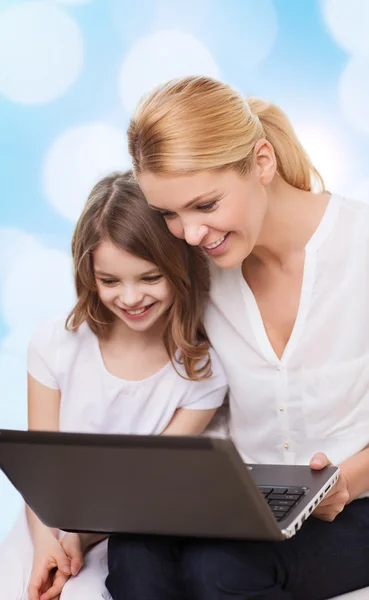 Gülümseyen anne ve dizüstü bilgisayar ile küçük kız — Stok fotoğraf