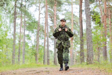 young soldier with backpack in forest clipart