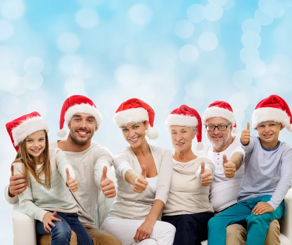 Família feliz em chapéus de santa mostrando polegares para cima — Fotografia de Stock