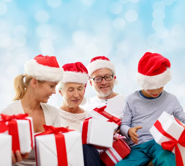 Familia feliz en sombreros de santa helper con cajas de regalo —  Fotos de Stock