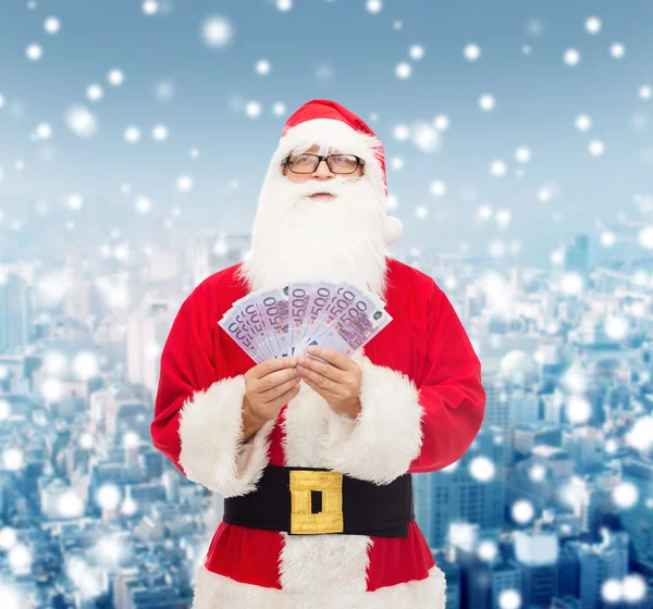 Hombre disfrazado de santa claus con dinero en euros — Foto de Stock