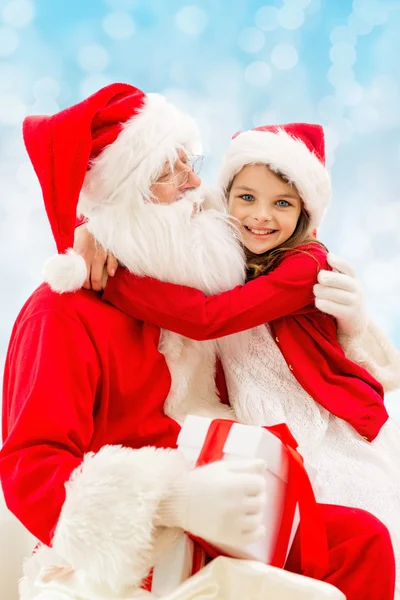 Lachende meisje met santa claus — Stockfoto