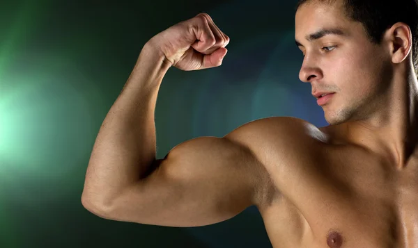 Närbild på ung man flexar och visar biceps — Stockfoto