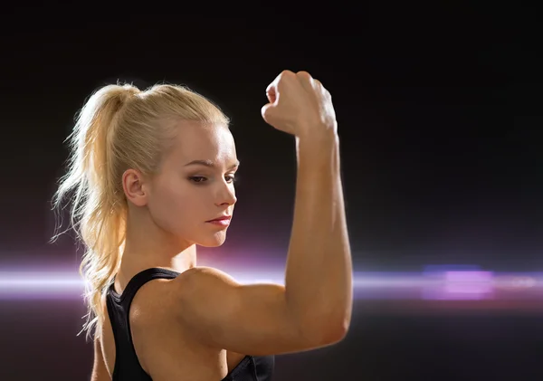 Close up of athletic woman flexing her biceps — Stock Photo, Image