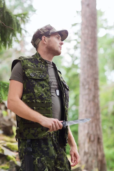 Young soldier or hunter with knife in forest — Stock Photo, Image