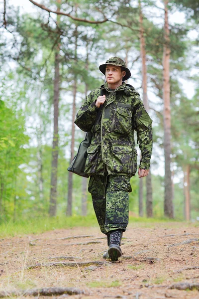 Junger Soldat oder Jäger mit Waffe im Wald — Stockfoto