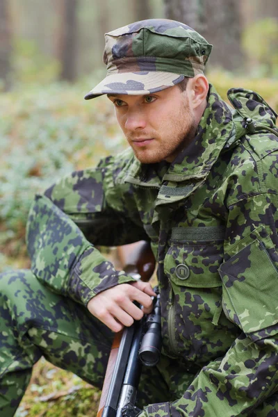 Молодой солдат или охотник с пистолетом в лесу — стоковое фото