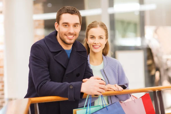 Gelukkig jong paar met boodschappentassen in winkelcentrum — Stockfoto