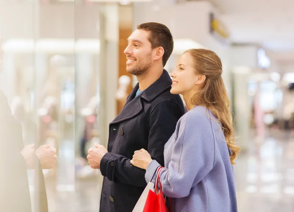 Gelukkig jong paar met boodschappentassen in winkelcentrum — Stockfoto