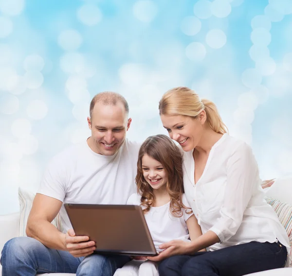 Улыбающаяся семья с ноутбуком — стоковое фото