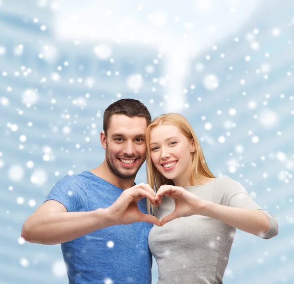 Lyckliga paret gör hjärtat gest och kramas — Stockfoto