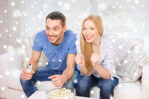 Couple souriant regarder la télévision à la maison — Photo