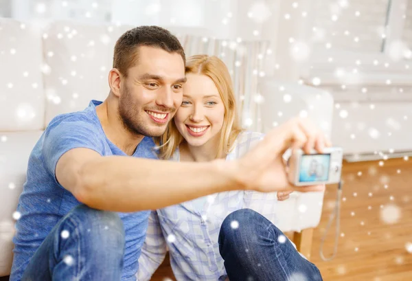 Casal sorridente tirando foto com câmera digital — Fotografia de Stock