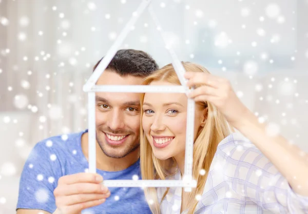 Sorrindo casal segurando modelo de casa em casa — Fotografia de Stock