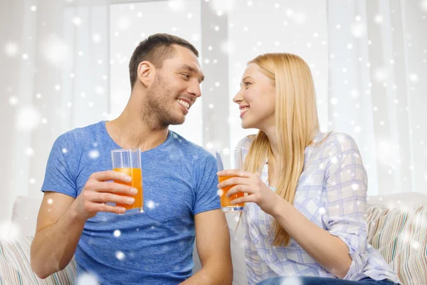 Smiling happy couple at home drinking juice — Stock Photo, Image