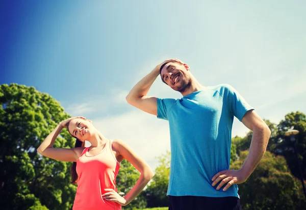 Sorridente coppia che si estende all'aperto — Foto Stock