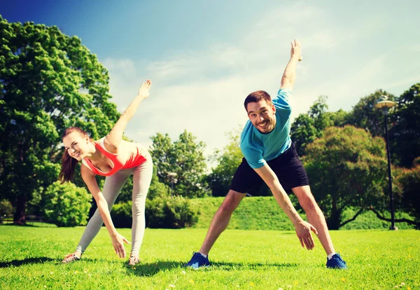 Smiling couple stretching outdoors — Stockfoto