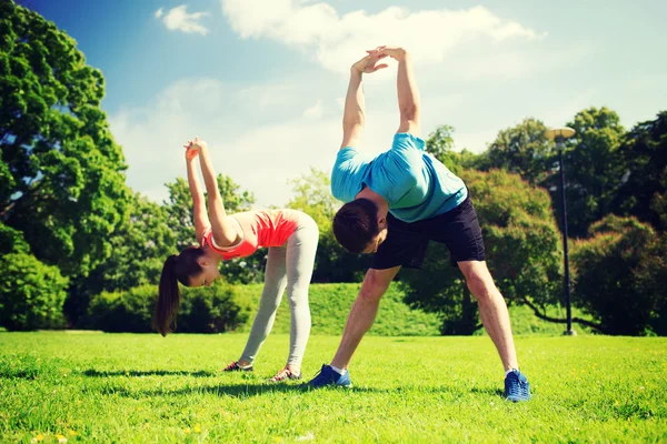 Smiling couple stretching outdoors — Stockfoto