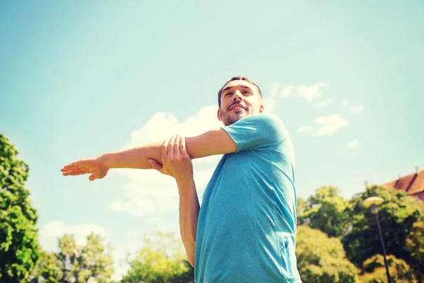 Glimlachende man die zich uitstrekt buiten — Stockfoto