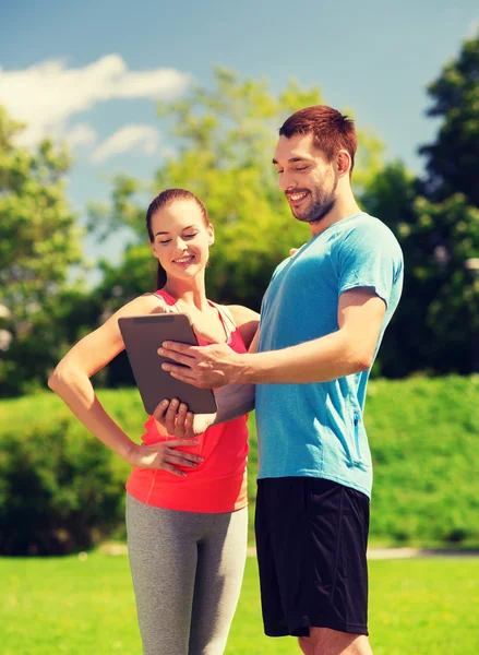 Sonriente pareja con tableta pc al aire libre — Foto de Stock