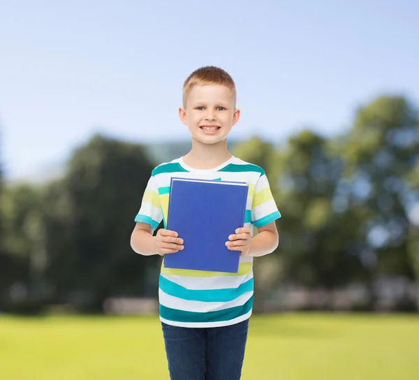 Sorrindo menino estudante com livro azul — Fotografia de Stock