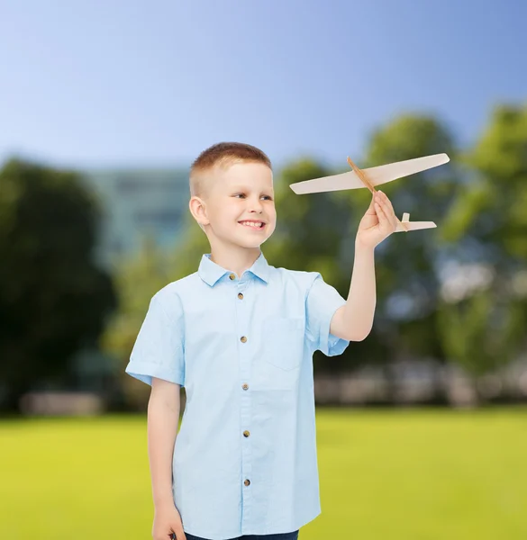 Lachende jongetje houden een houten vliegtuig model — Stockfoto