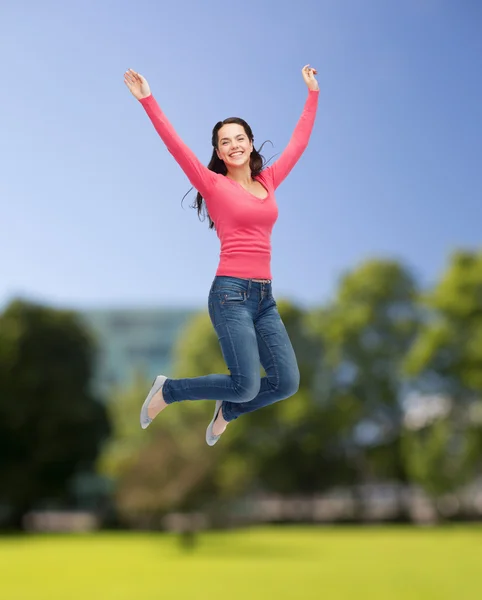 空を飛び跳ねる笑顔の若い女性 — ストック写真