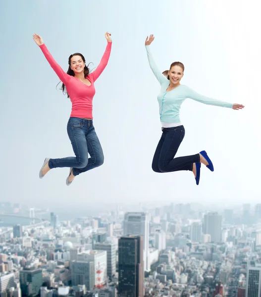 Улыбающиеся молодые женщины, прыгающие в воздухе — стоковое фото