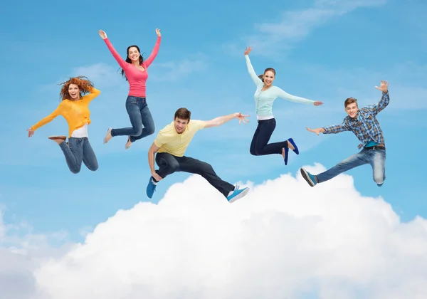 group of smiling teenagers jumping in air