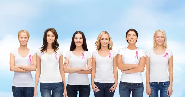 Mulheres sorridentes com fitas de conscientização de câncer rosa — Fotografia de Stock