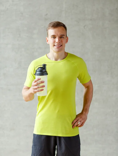Улыбающийся мужчина с бутылкой протеинового коктейля — стоковое фото
