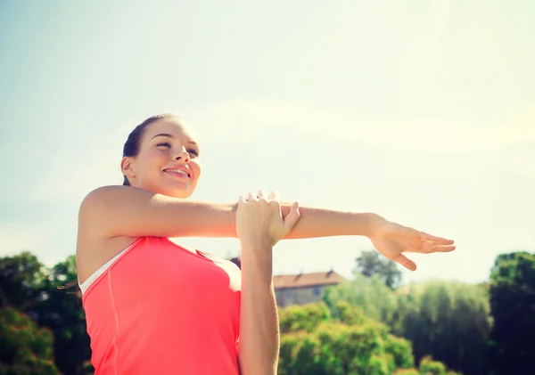 Mujer sonriente estirándose al aire libre — Foto de Stock