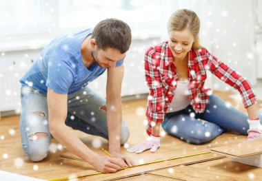 smiling couple measuring wood flooring clipart