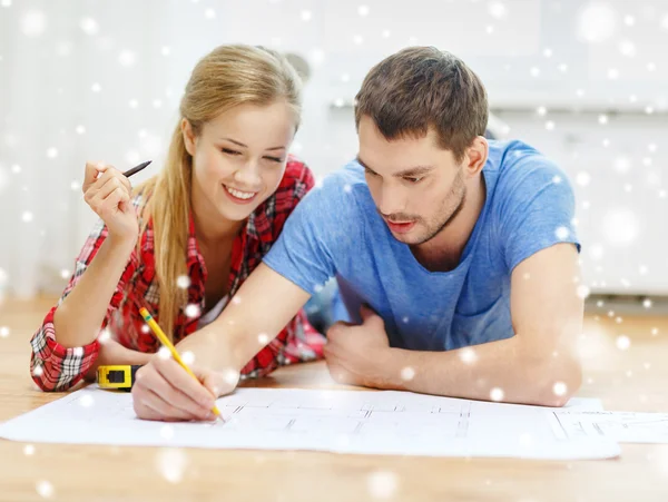 Couple souriant avec plan à la maison — Photo