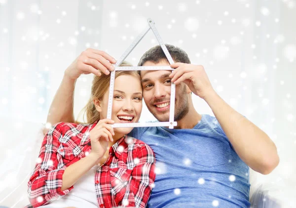 Smiling couple with house made of measuring tape — Stock Photo, Image