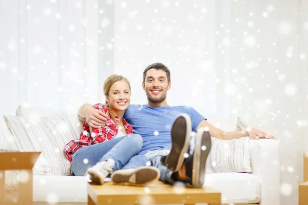 Casal sorridente relaxante no sofá em nova casa — Fotografia de Stock