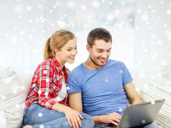 Casal sorridente com computador portátil em casa — Fotografia de Stock