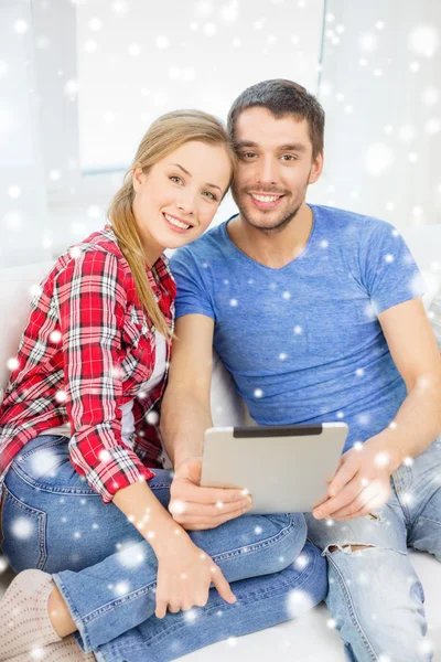Улыбающаяся пара с планшетным компьютером дома — стоковое фото