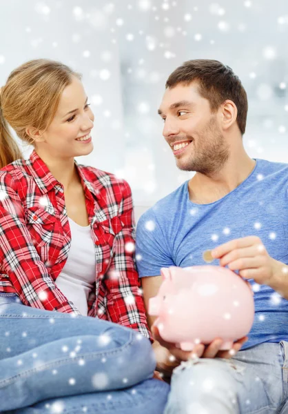 Casal sorridente com banco de pombos sentado no sofá — Fotografia de Stock