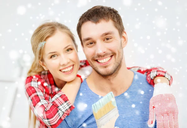 Couple souriant avec pinceau à la maison — Photo