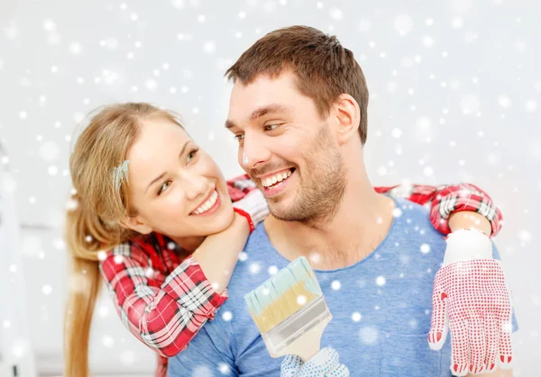 Smiling couple with paintbrush at home — Stock Photo, Image