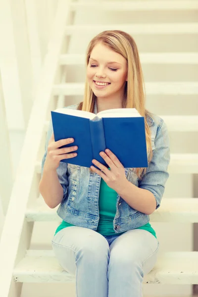 Sorridente adolescente leitura livro — Fotografia de Stock