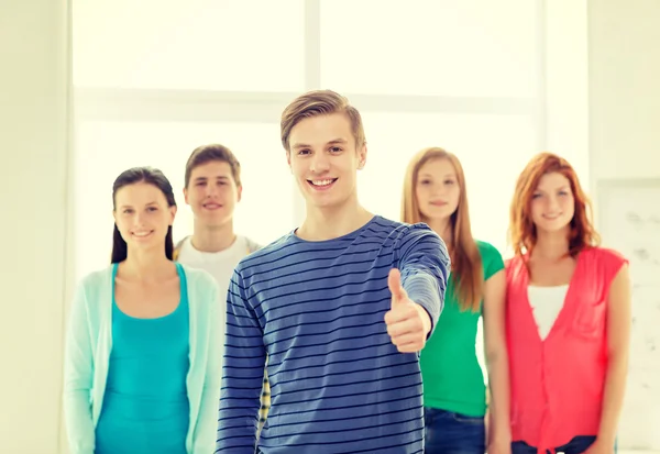 Estudiantes sonrientes con adolescente en frente — Foto de Stock