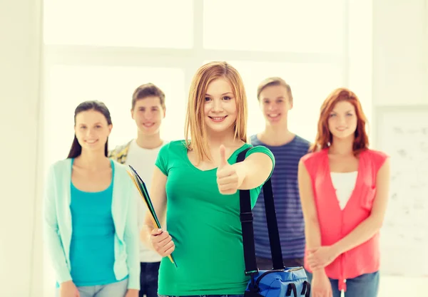 Lächelnde Studenten mit Teenager-Mädchen vor — Stockfoto