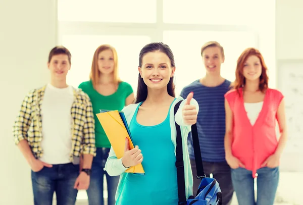 Lächelnde Studenten mit Teenager-Mädchen vor — Stockfoto