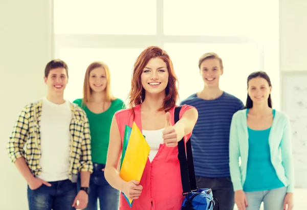 Studenti sorridenti con ragazza adolescente di fronte — Foto Stock