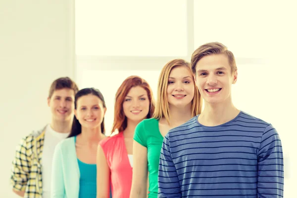 Lächelnde Studenten mit pubertierendem Jungen vor — Stockfoto