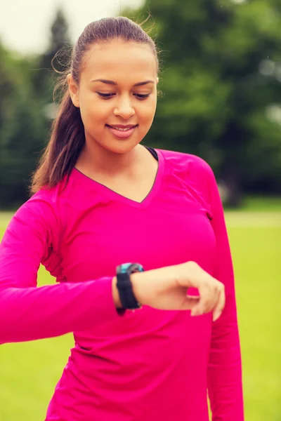 Sonriente joven con reloj de ritmo cardíaco — Foto de Stock