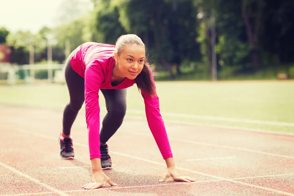 Lächelnde junge Frau läuft im Freien auf Gleis — Stockfoto