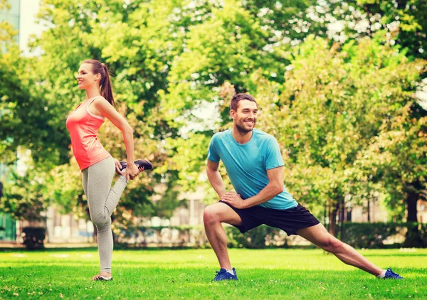 Lächelndes Paar streckt sich im Freien — Stockfoto